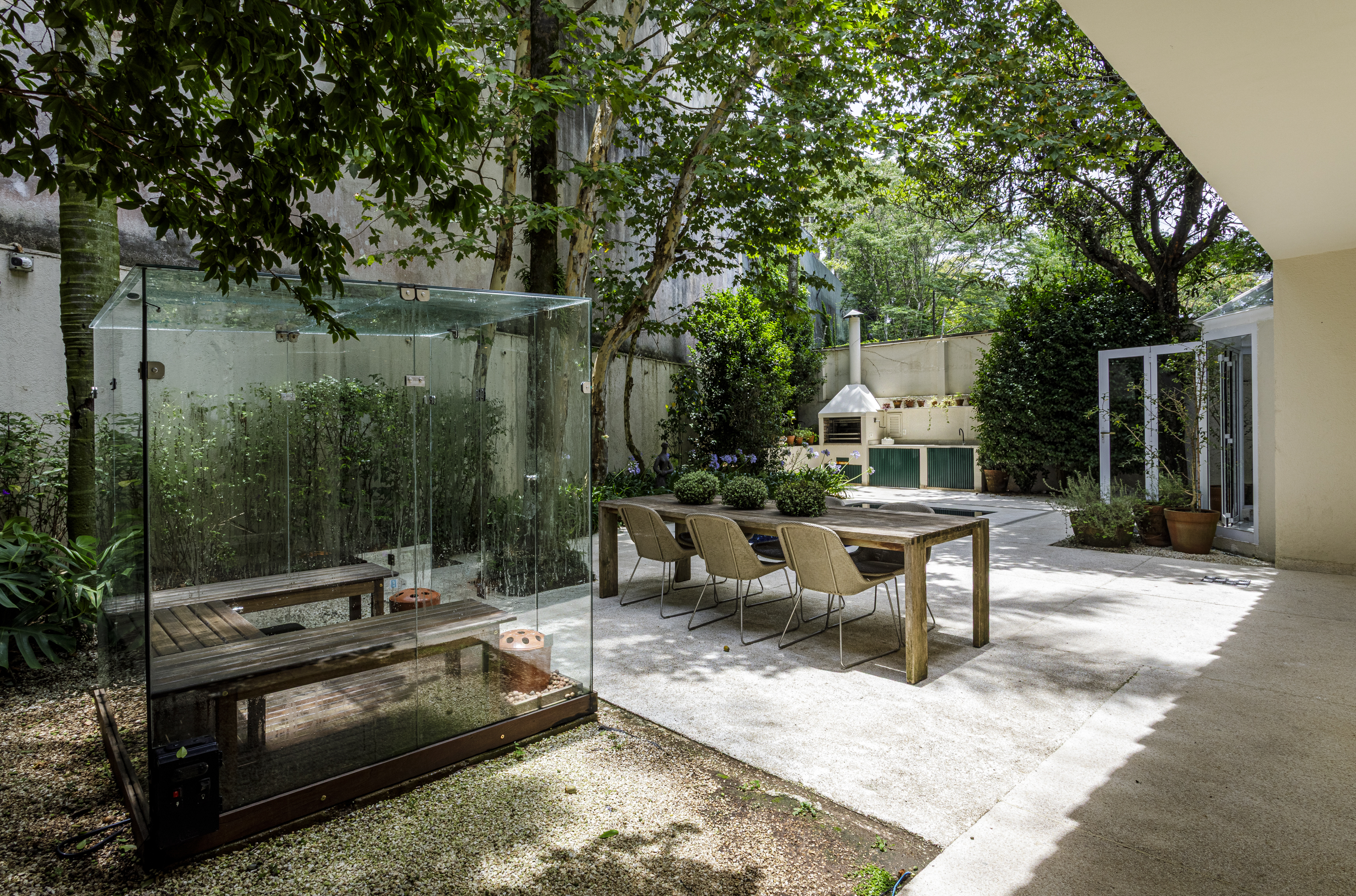 Terraço com mesa e sauna envidraçada