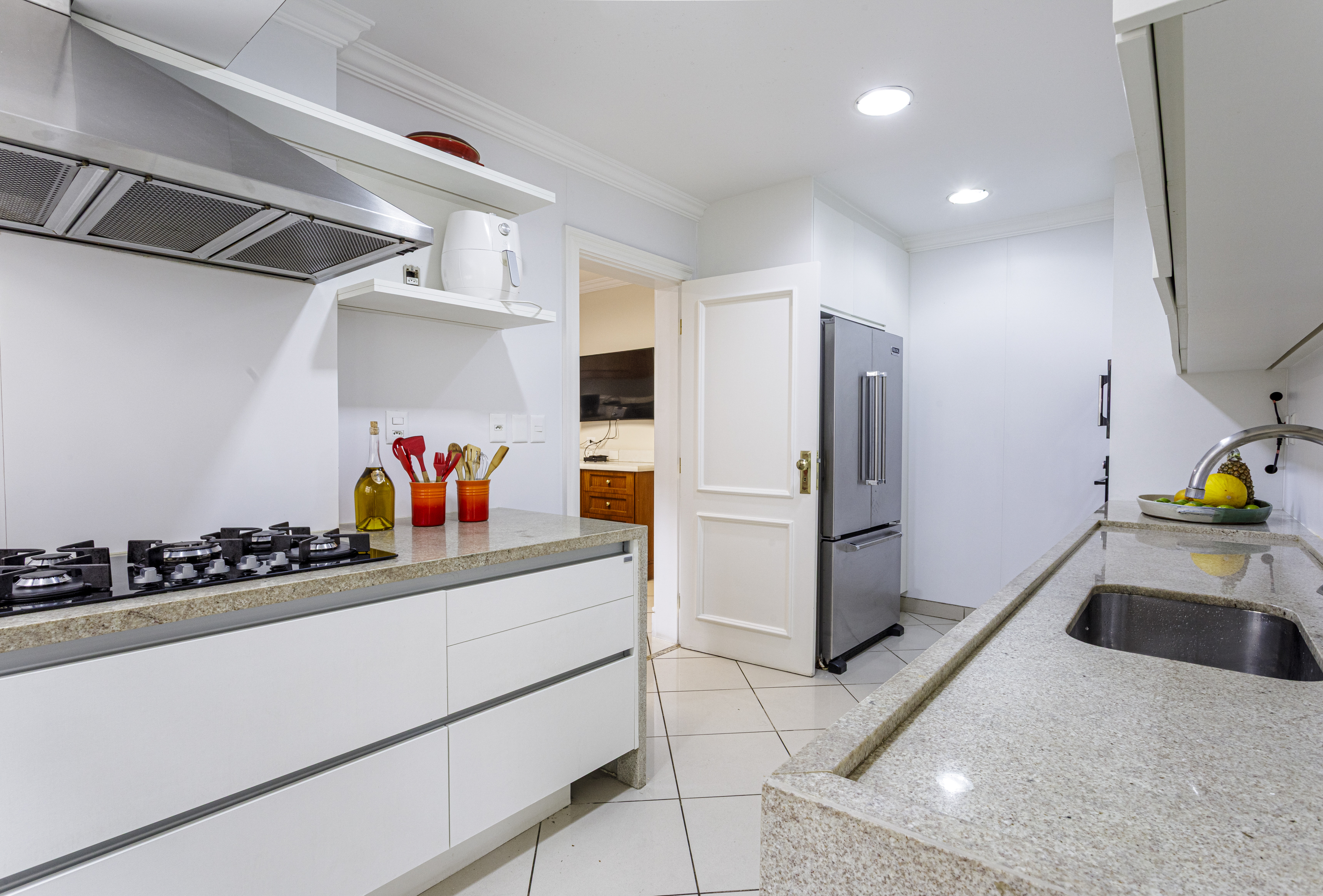 Cozinha branca com bancada em pedra